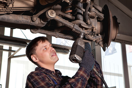 汽车修理工机械师在汽车修理或维修店服务站用扳手拆
